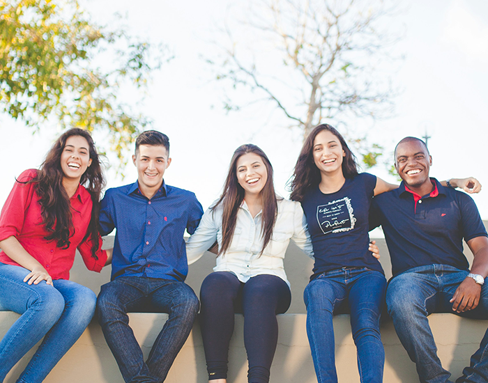 home-page-students Students sitting together on a bench with their arms around each other.
